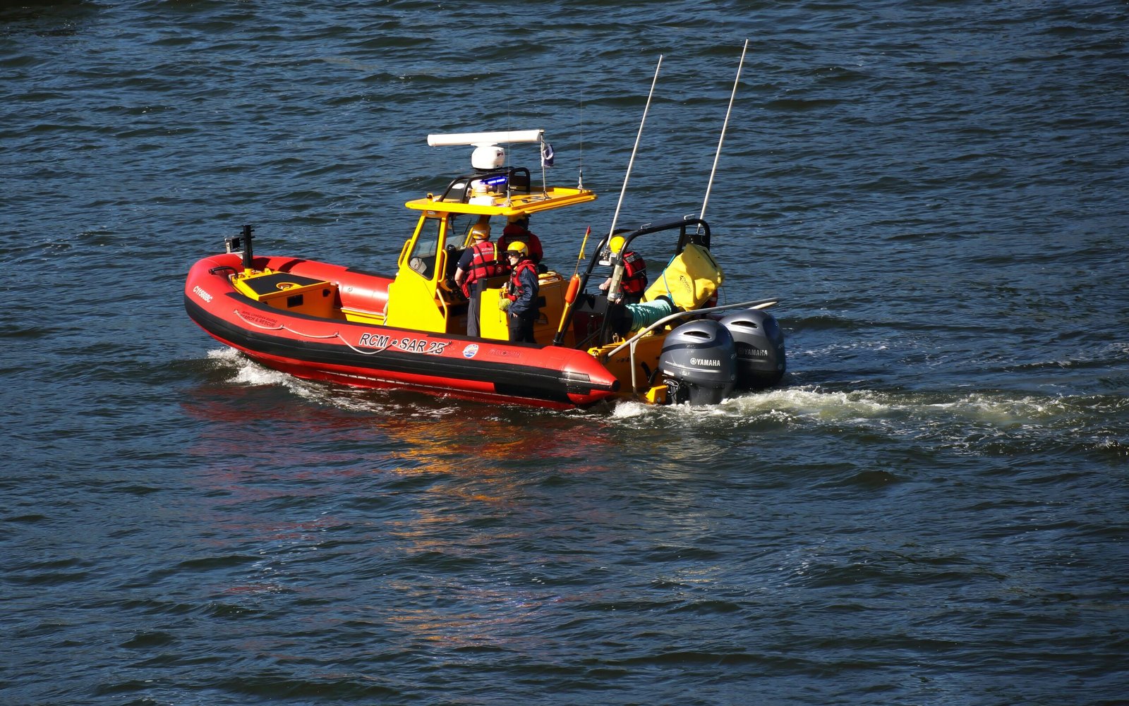 A red and yellow boat traveling down a river